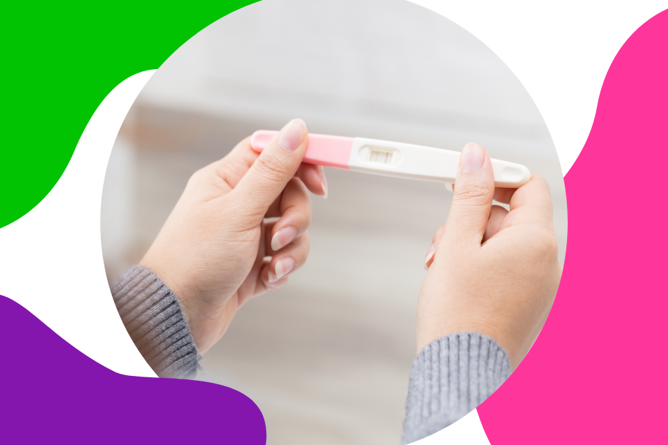 zwei Frauenhände halten einen positiven Schwangerschaftstest und deuten so die Fertilität an