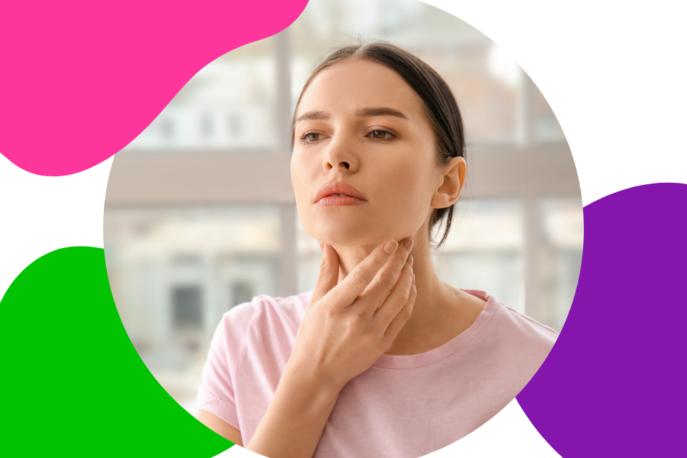 Junge Frau mit braunen Haaren greift sich an ihren Hals und tastet nach einem Knoten oder Kropf