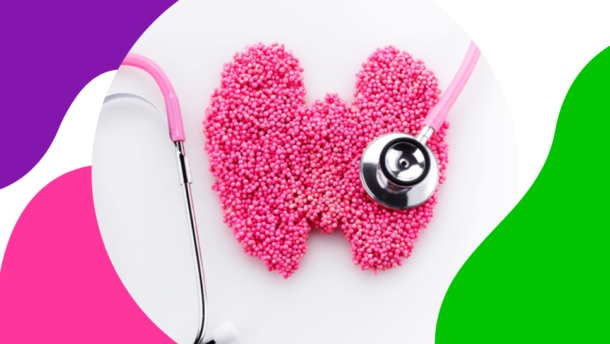 eine Schilddrüse aus rosa Kugeln liegt auf einem weißen Tisch und wird mit einem rosa Werkzeug nach Schilddrüsenkrebs abgetastet