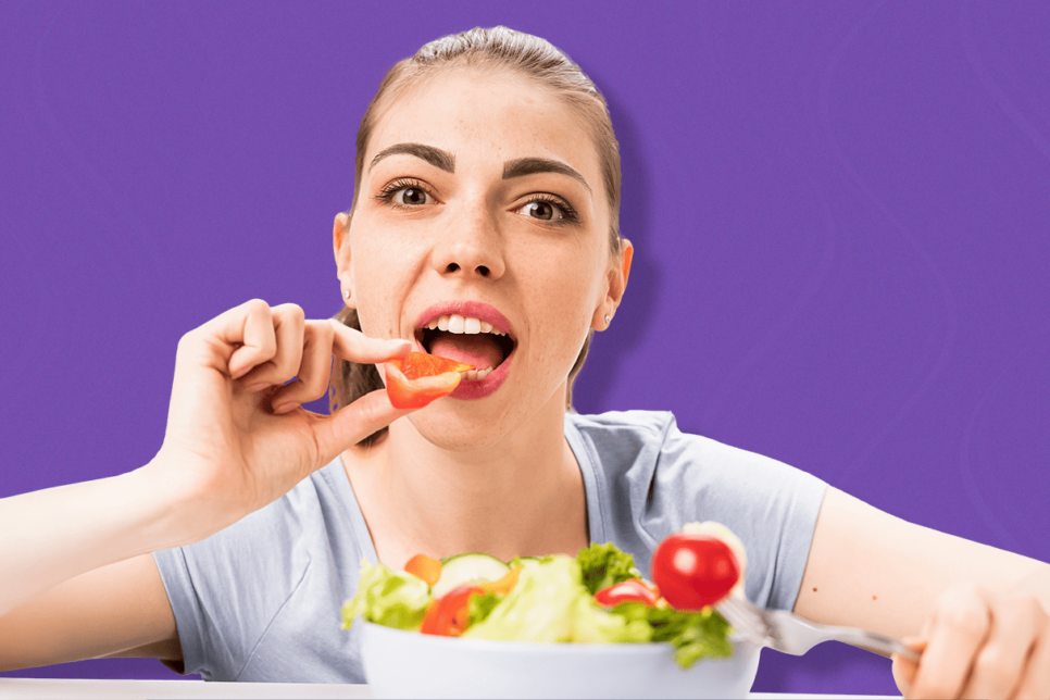 Mujer sosteniendo verdura en la mano y con plato de ensalada