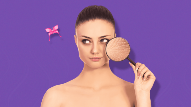 Mujer sosteniendo lupa sobre su rostro con detalle en su piel